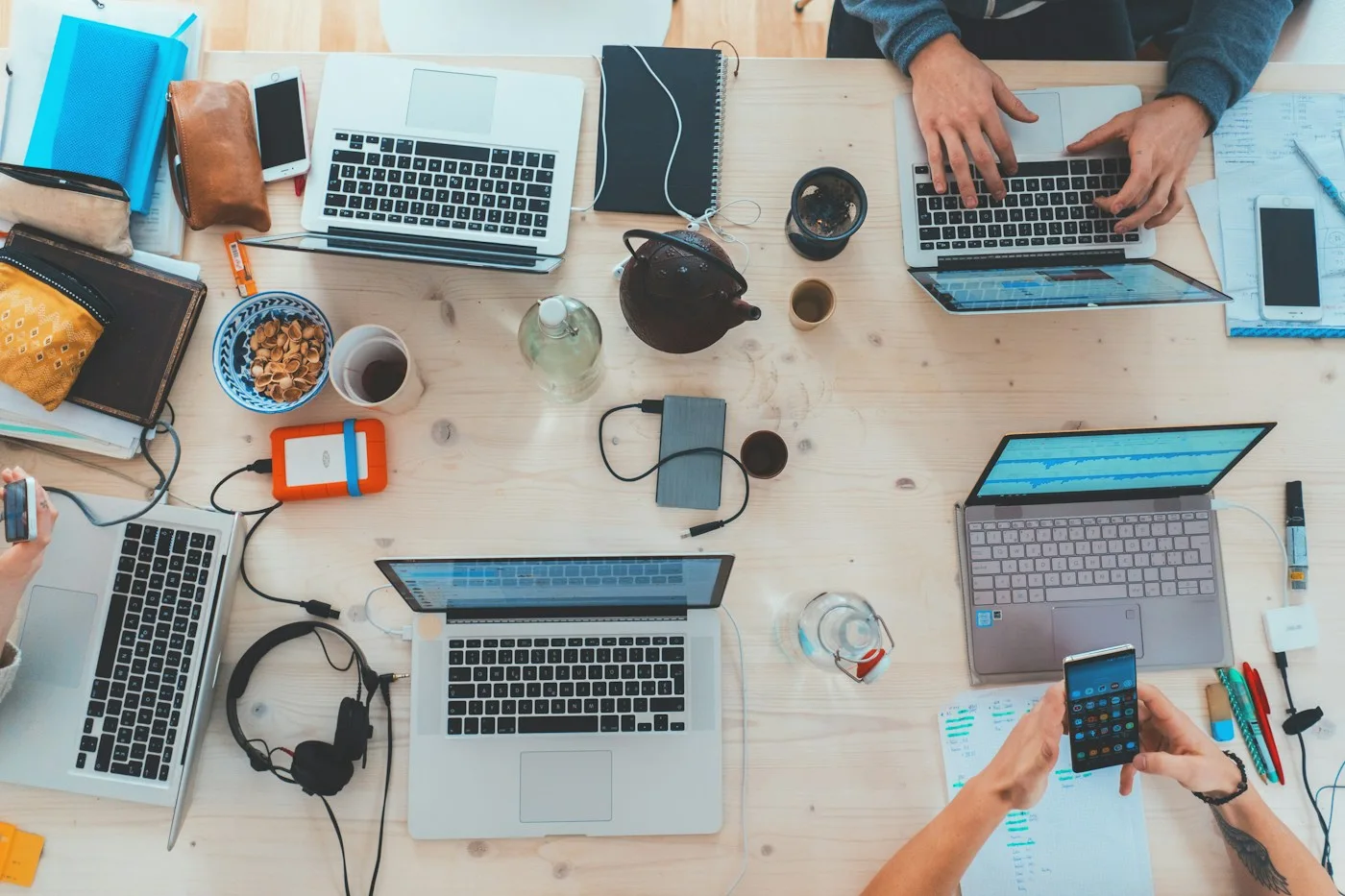 Technology professionals working together with laptops and connected devices